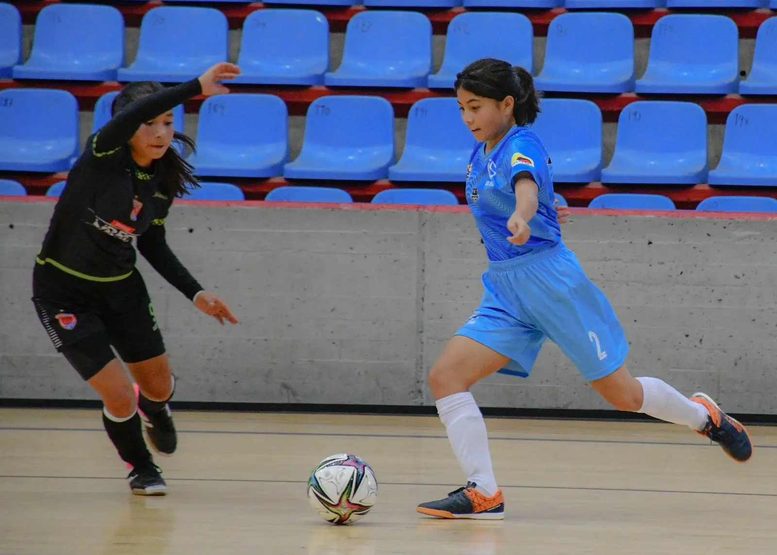 Women playing futsal in an indoor sports hall; illustrative archive photograph