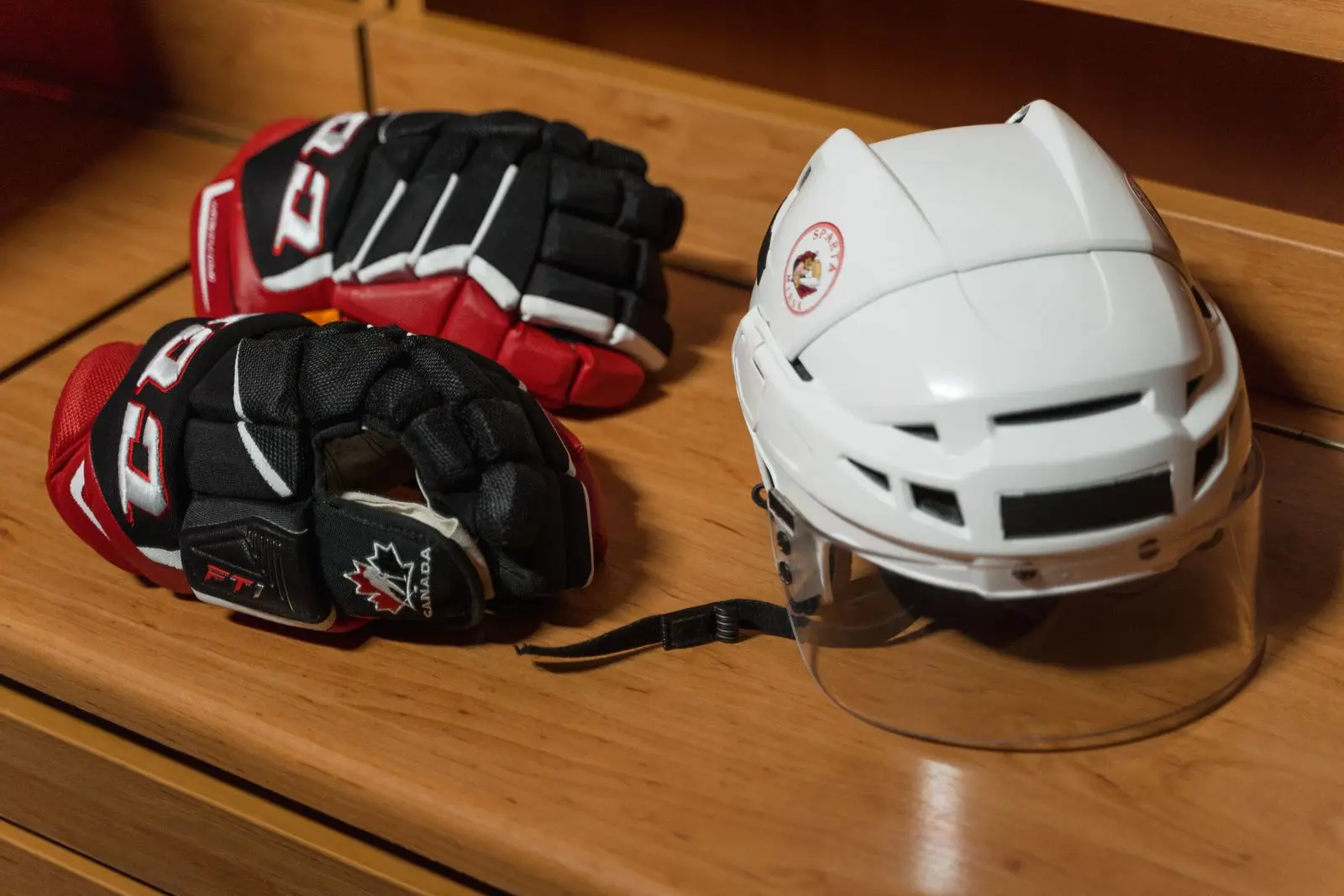 Ice hockey helmet and gloves on a bench