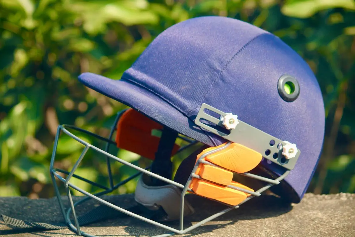 Blue cricket helmet with a protective grille