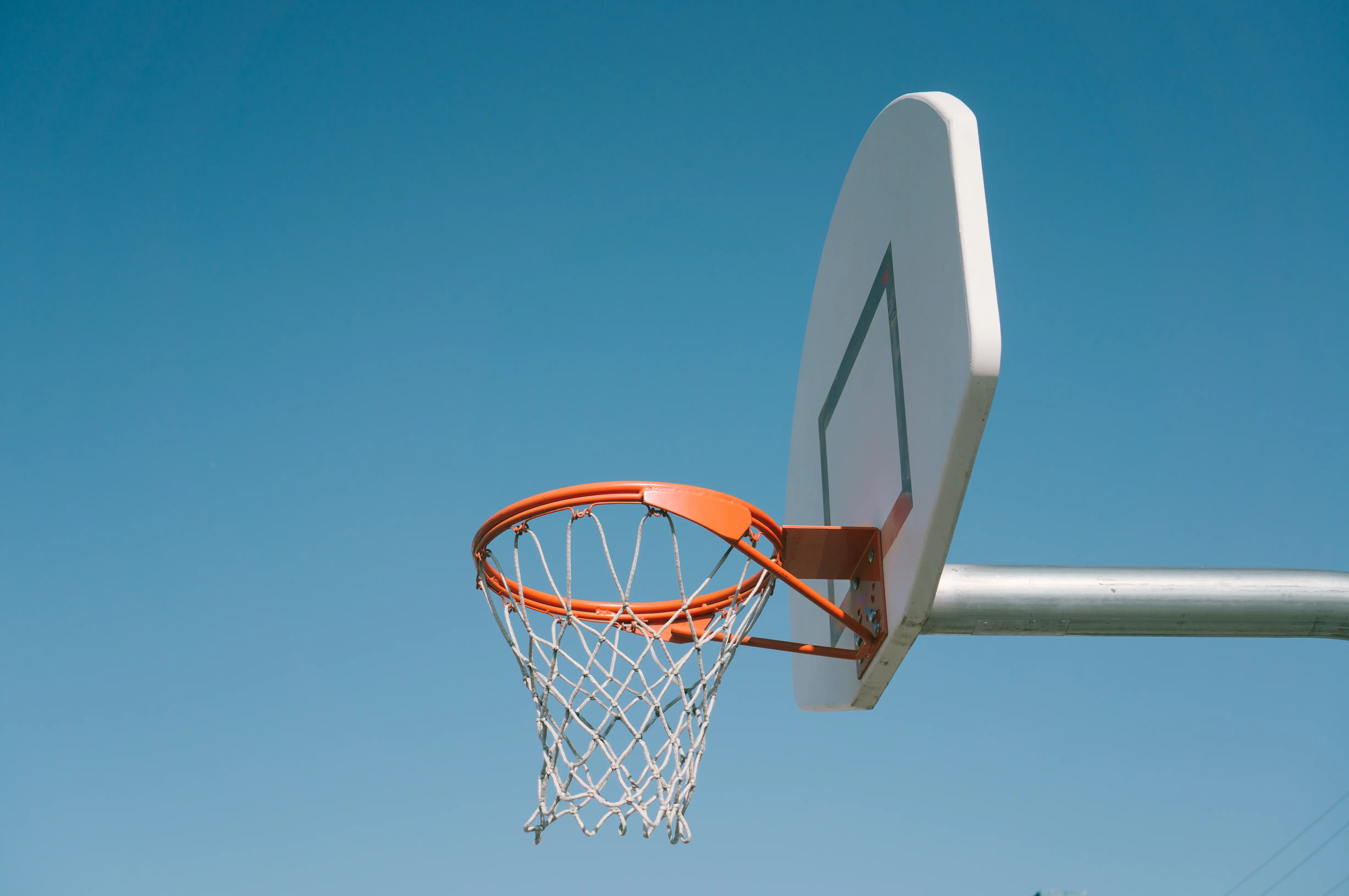 Outdoor basketball hoop against a blue sky