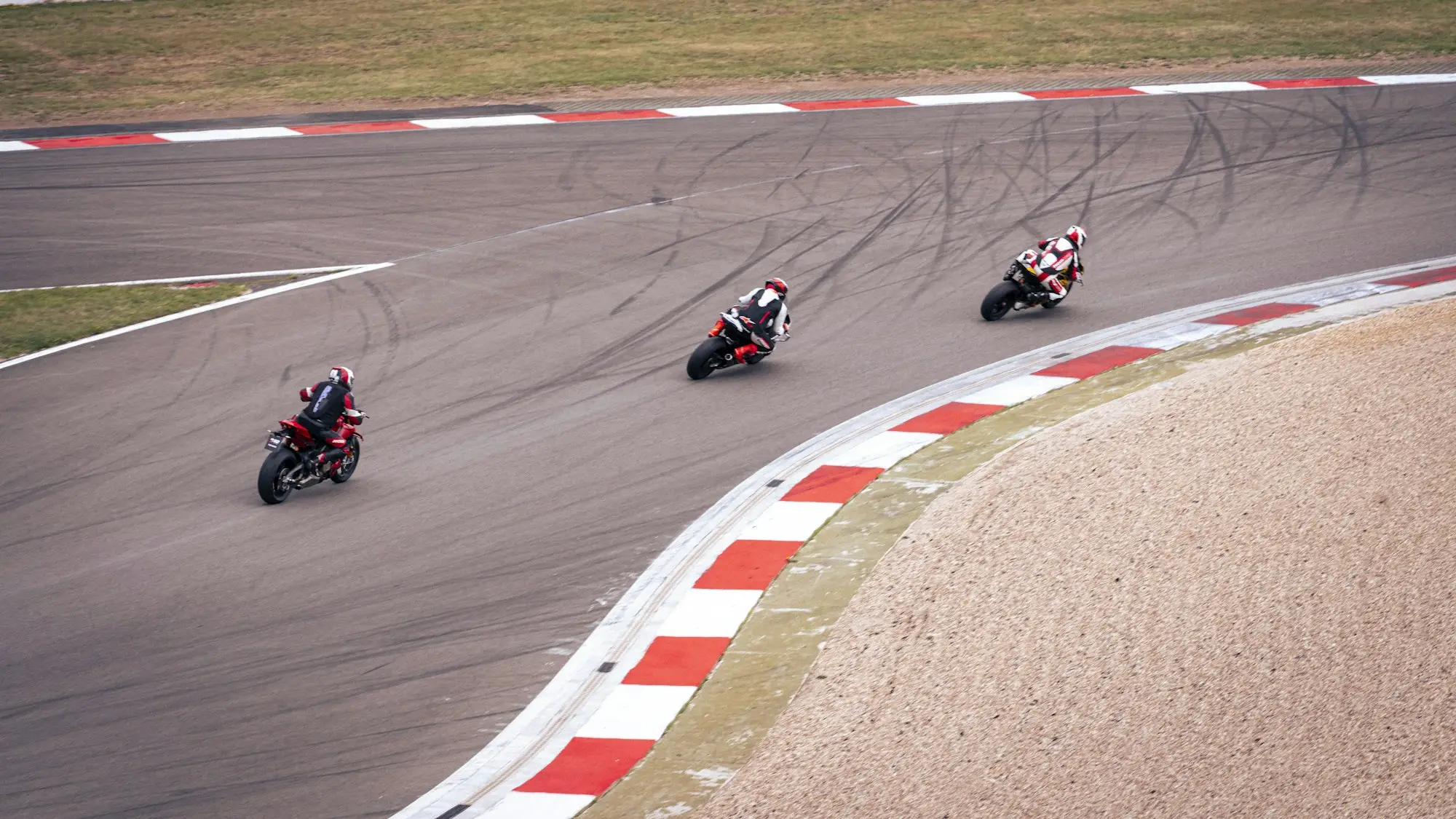 Motorcycle racers leaning through a circuit corner