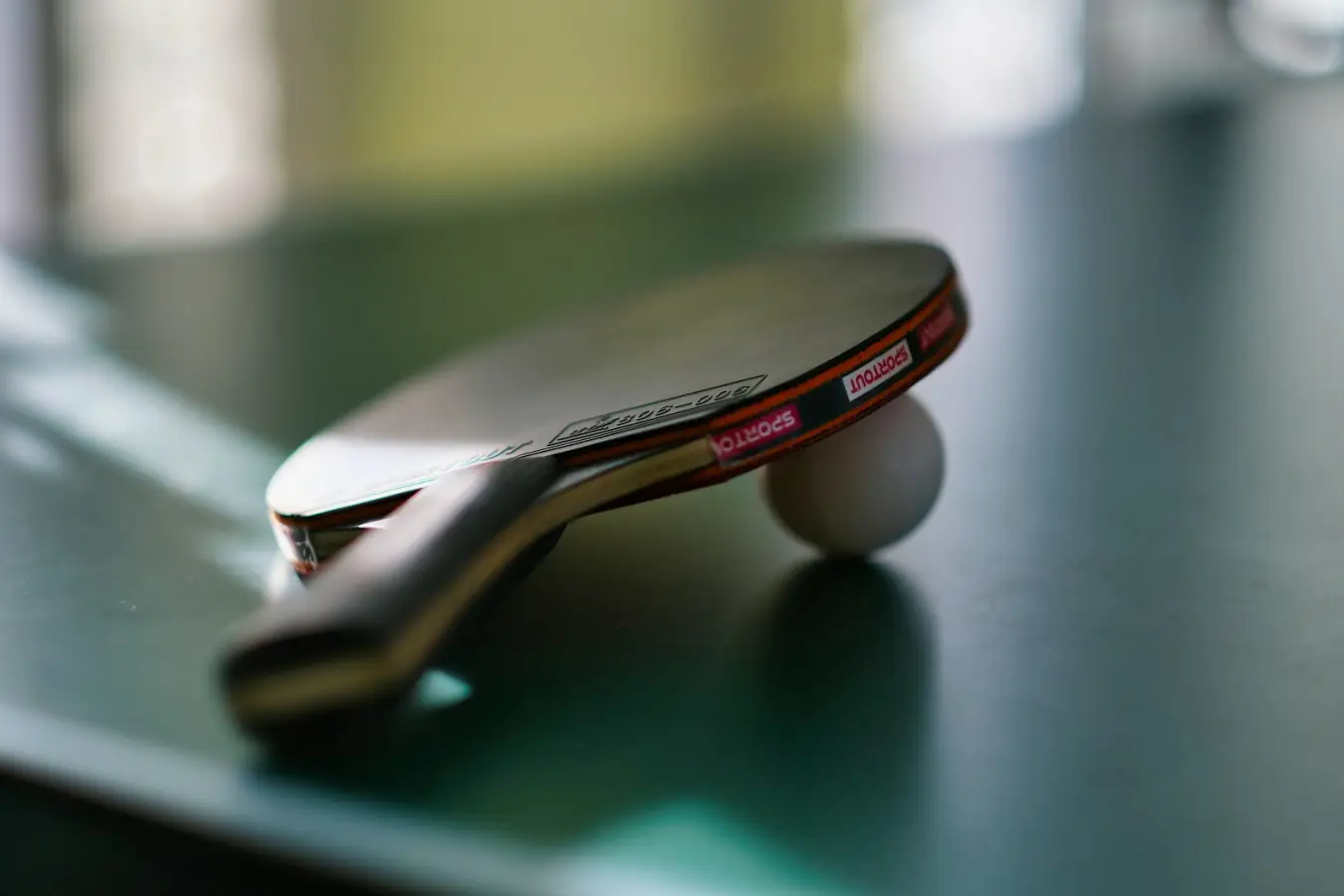 Table tennis racket resting on a ball; illustrative photograph