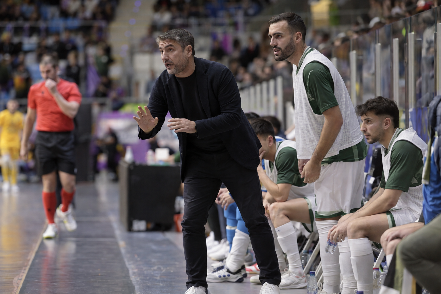Futsal coach instructing players during a professional match