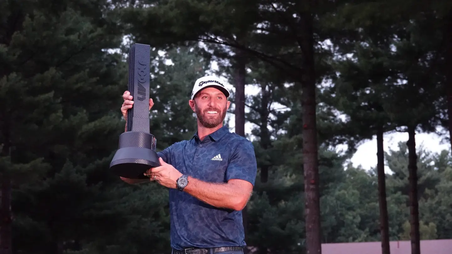 Dustin Johnson holds a trophy at a LIV Golf tournament