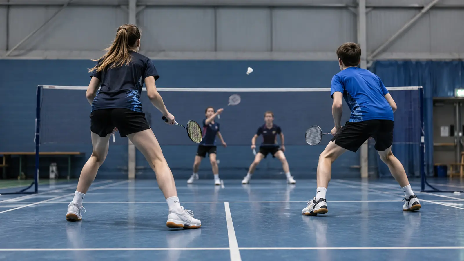 AI-generated editorial illustration of conceptual junior mixed doubles badminton rally; not the actual event or named players