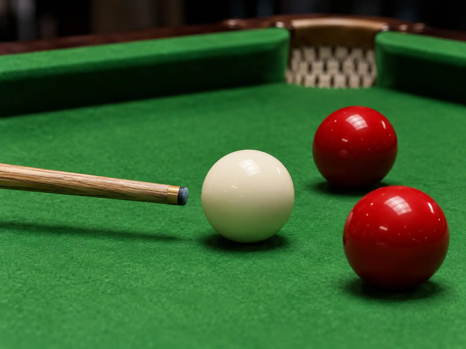 Conceptual close-up of a snooker cue and balls on green baize
